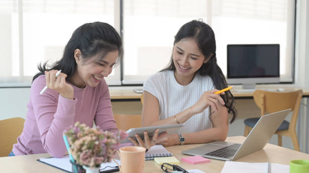 istock Friendly female colleagues discussing new project together at creative office. 1394353579