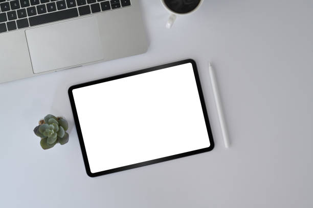 istock Top view white office desk with digital tablet, laptop, glasses and coffee cup. 1394354548