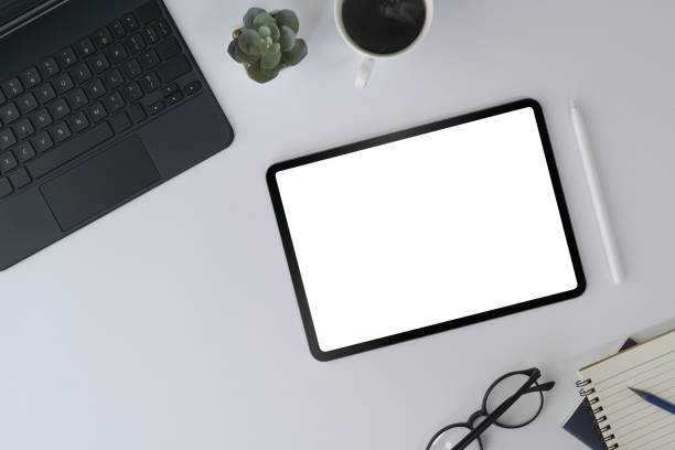 istock White office desk with digital tablet, laptop, glasses and notebook. Top view. 1394354550