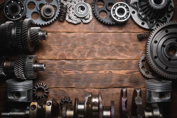 Car spare parts on the wooden flat lay workbench background with copy space.