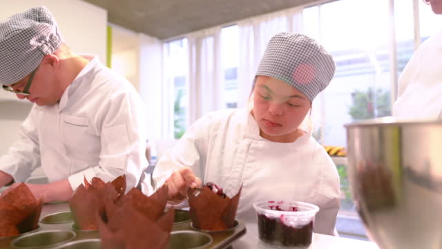 Focused young woman with Down Syndrome learning to bake in class