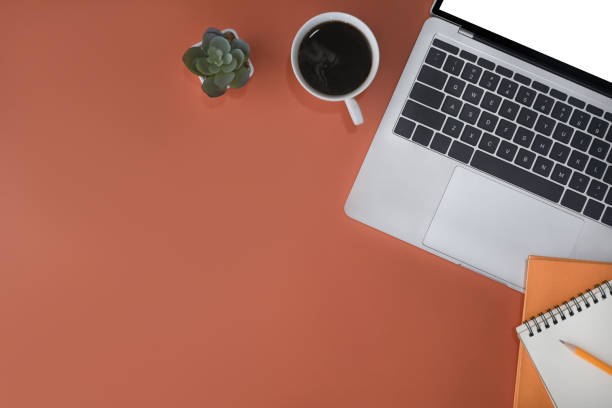 istock Laptop computer, notebook and coffee cup on orange background. Stylish workplace, Top view. 1394355915