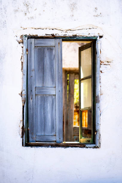 istock Antique window on a white old wall and gold light inside. 1394361871