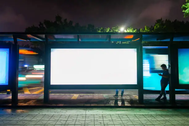 Photo of Young man waiting for public transportation at rush hour bus stop in Shenzhen, China