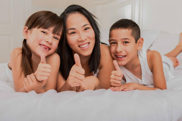 istock Happy mom and two children in bed 1394363078