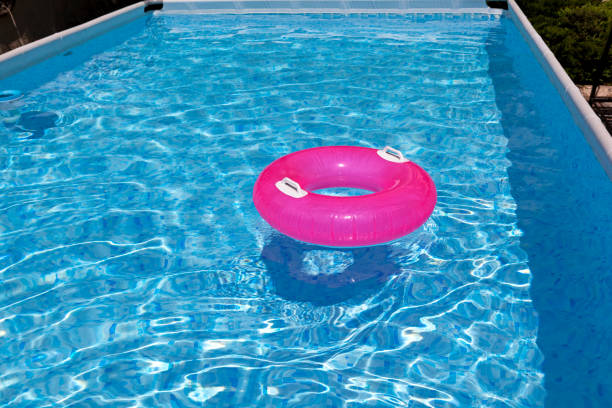 marco piscina exterior. círculo de natación inflable en la superficie del agua. verano, día soleado - plastic ring fotografías e imágenes de stock