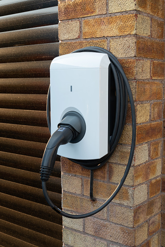 Close up of a type C domestic electric vehicle charging unit installed on the wall of a house