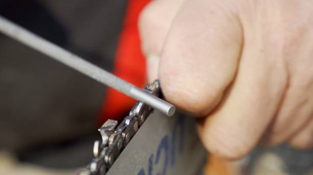 istock Chainsaw chain sharpening with a round file. Closeup macro view. Forestry or arborist concept. 1394364679