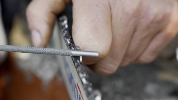istock Chainsaw chain sharpening with a round file. Closeup macro view. Forestry or arborist concept. 1394364689