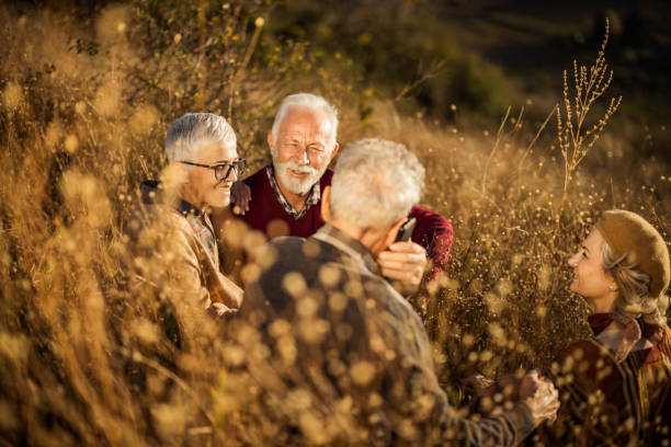 istock Happy seniors talking during autumn day in tall grass. 1394366340