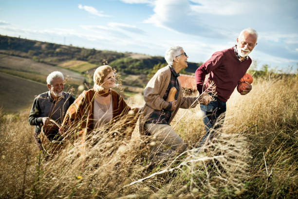 istock Happy mature couples going on a picnic in autumn day. 1394366506