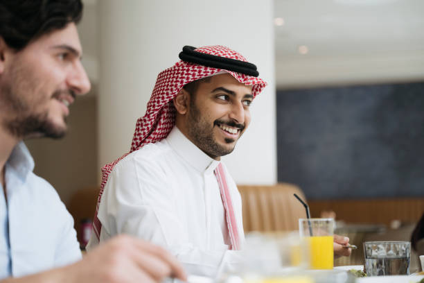 junge saudische geschäftsleute unterhalten sich beim mittagessen - gericht des mittleren ostens stock-fotos und bilder