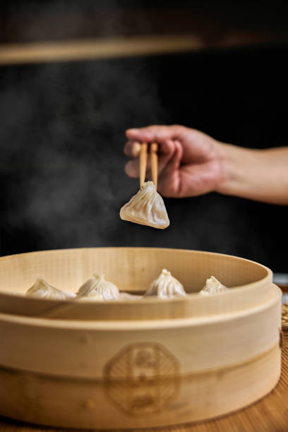 istock Hand taking  Xiaolongbao with wooden chopsticks. 1394371181