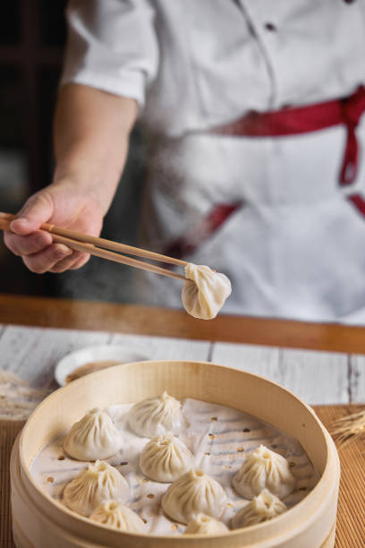 istock Hand taking  Xiaolongbao with wooden chopsticks. 1394371929
