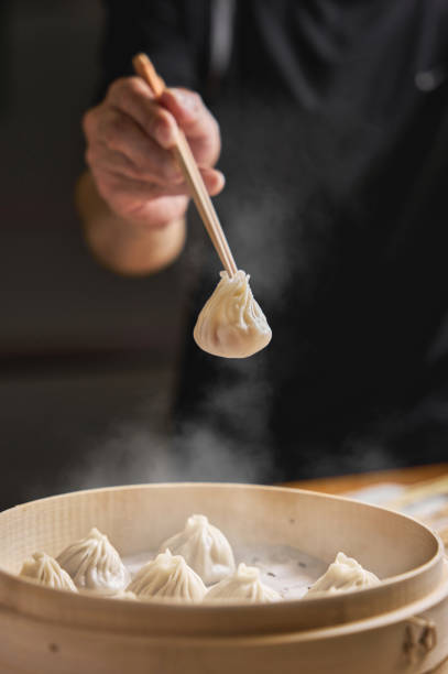 istock Hand taking  Xiaolongbao with wooden chopsticks. 1394371935