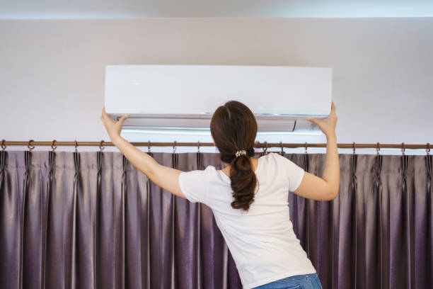 istock Woman cleaning and washing a air conditioning filter. 1394372100