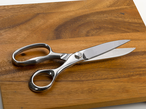 Kitchen scissors on wooden cutting board