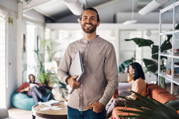 istock Young happy businessman standing in an office at work 1394373251