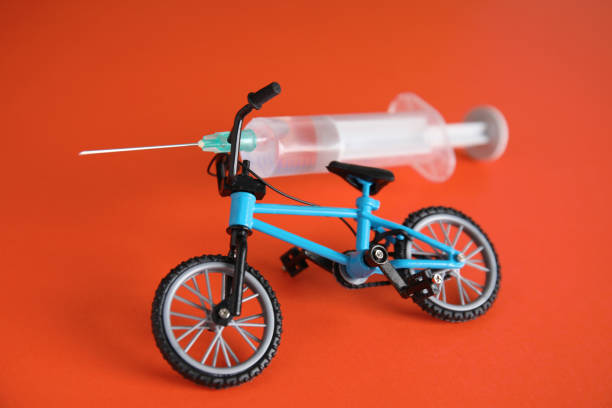 Bike model and syringe on red background. Using doping in cycling sport concept Bike model and syringe on red background. Using doping in cycling sport concept erythropoietin stock pictures, royalty-free photos & images