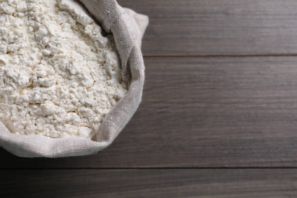 istock Sack with flour on wooden background, top view. Space for text 1394374636