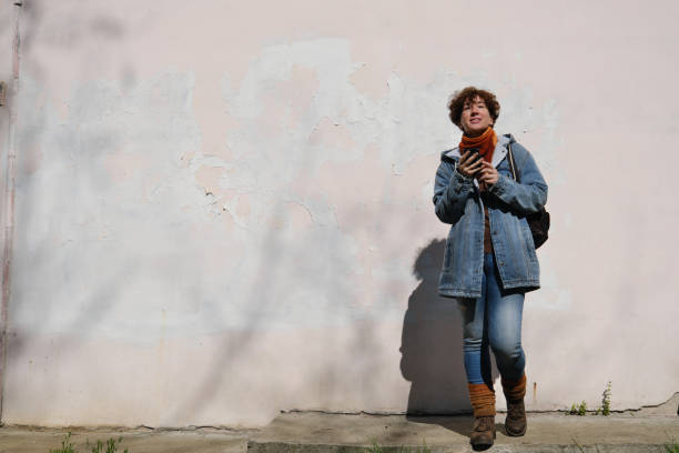 istock Woman is using phone on sunny street 1394377458