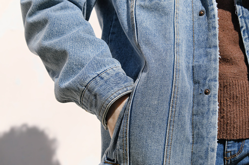 Person is holding hand in denim jacket's pocket