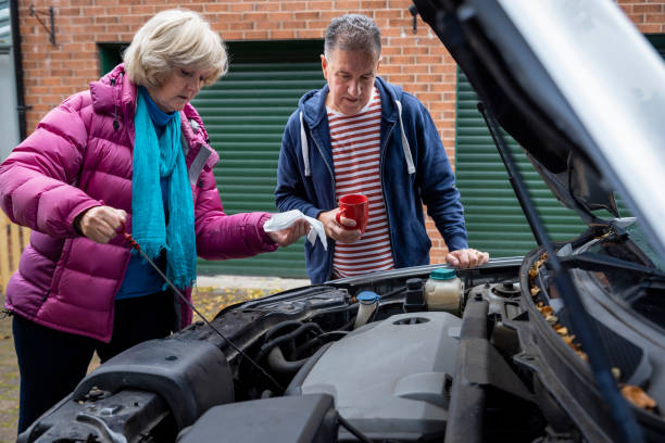 lending a helpful hand - old men car oil imagens e fotografias de stock