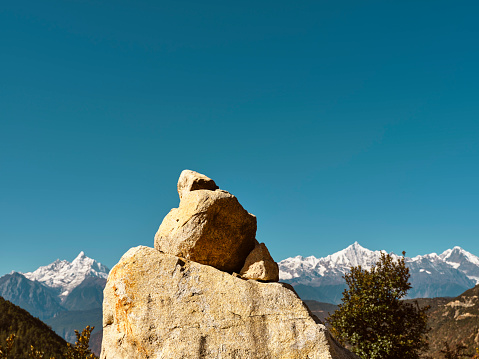 huge prayer stone with meili snow mountain in background in china's yunnan province