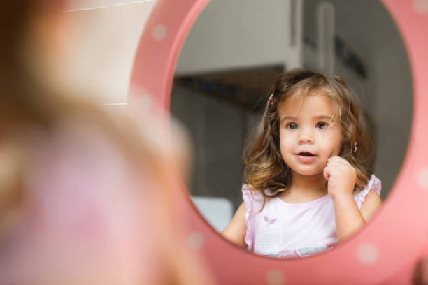Beautiful little girl applying make up.