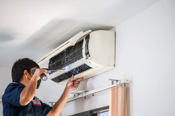 istock Male technician using a screwdriver fixing modern air conditioner, Male technician cleaning air conditioner indoors, Maintenance and repairing concepts 1394378921