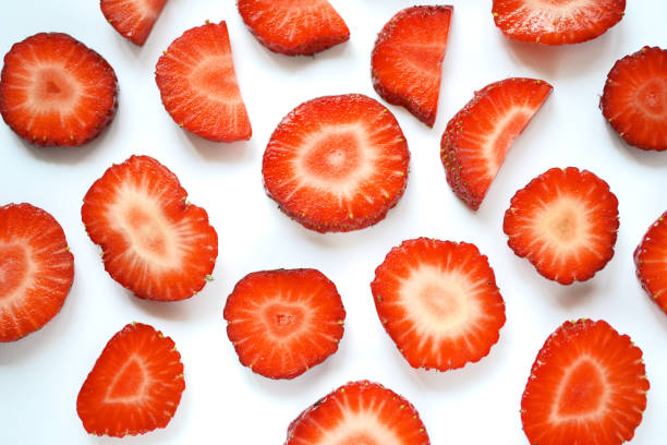 istock Slices of ripe strawberries in a seamless pattern isolated on a white background. 1394381808