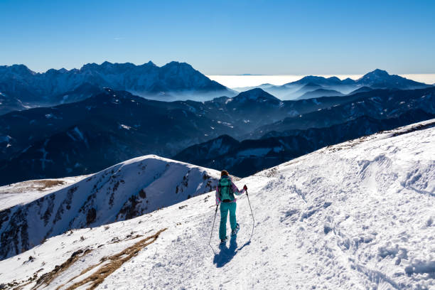 hochobir - femme sur un sentier de randonnée enneigé avec vue panoramique sur les karawanks en carinthie, alpes autrichiennes. ski de randonnée - apres ski winter hiking ski photos et images de collection