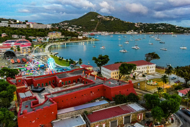 St. Thomas USVI An aerial view of St. Thomas located in the US Virgin Islands. The image shows the waterfront area of Charlotte Amalie, featuring boats in the harbor, Fort Christian, the VI Legislative building.  Taken in April 2022, the image includes carnival rides in an area referred to as Carnival Village. In the background is the Havensight and Yacht Haven areas of the island. st. thomas virgin islands photos stock pictures, royalty-free photos & images