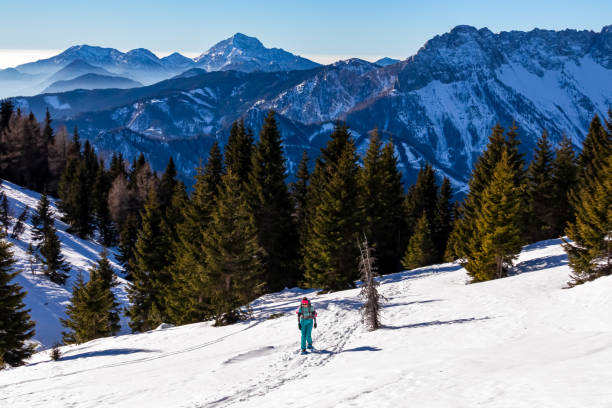 hochobir - femme sur un sentier de randonnée enneigé avec vue panoramique sur les karawanks en carinthie, alpes autrichiennes - apres ski winter hiking ski photos et images de collection