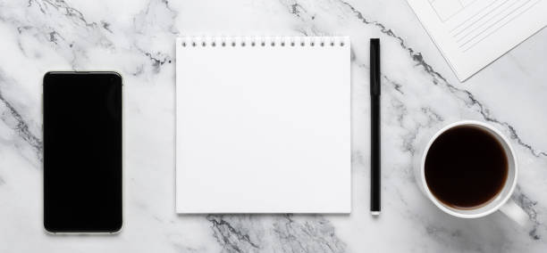 istock Office desk with blank notepad, phone and coffee on marbled background with copy space. Flat design, planning concept. 1394384030