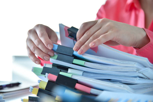 istock Accountant woman searching in stack of business documents. 1394385538