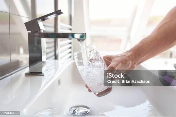Filling Up A Glass With Drinking Water From Bathroom Tap Stock Photo - Download Image Now