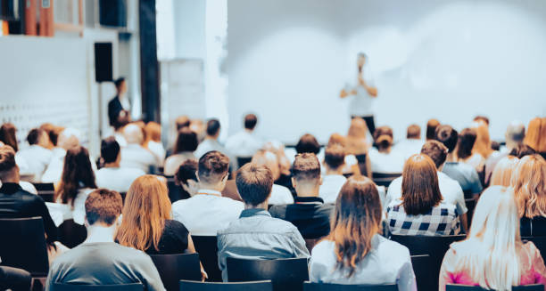 istock Rear View Of People During Seminar 1394389255