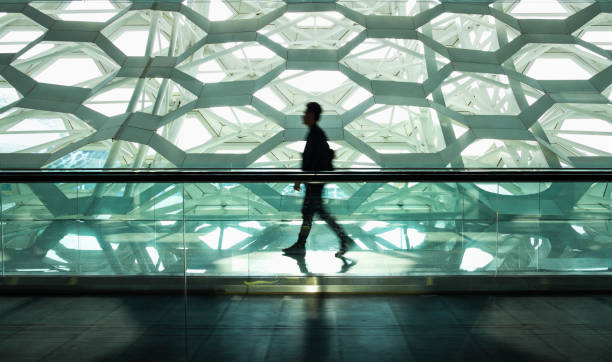 Man walking alone in modern corridor hallway
