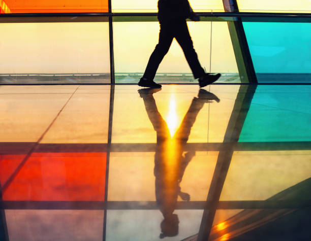 Low angle view of person walking through back lit corridor