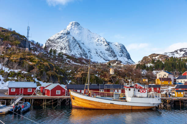 barca da pesca in legno e case colorate al porto di nusfjord. - fishing village nordic countries fjord foto e immagini stock