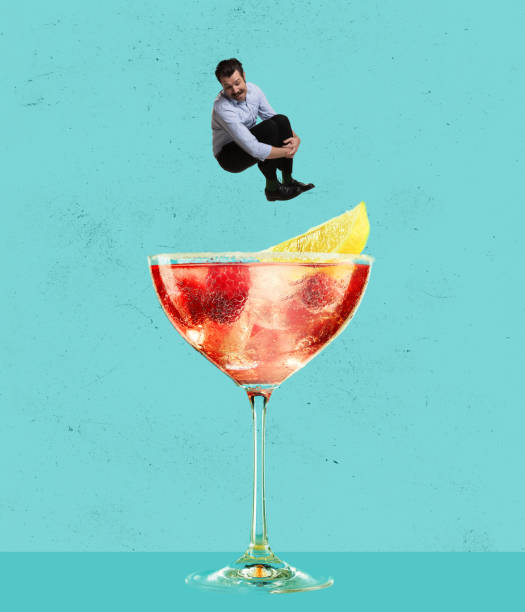 Contemporary art collage. Happy cheerful man jumping into refreshing tasty cocktail with fruity taste isolated over blue background Contemporary art collage. Happy cheerful man jumping into refreshing tasty cocktail with fruity taste isolated over blue background. Concept of alcohol, addiction, party, taste. Pop art style, ad martini glass photos stock pictures, royalty-free photos & images