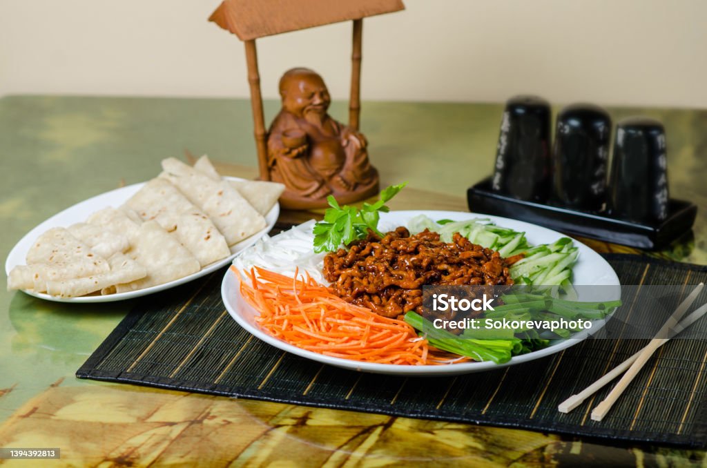 Peking Pork. Pork is served with carrots, cucumbers, green onions. Dish in a Chinese restaurant. Beijing Stock Photo