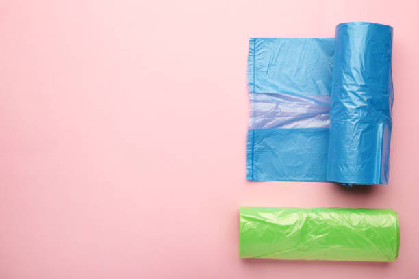 istock A lot of colored plastic bags rolls on a pink background. 1394393366