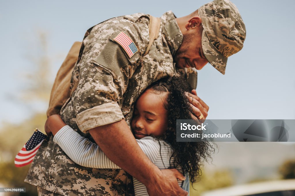 Emotional soldier saying farewell to his daughter Emotional soldier saying his goodbye to his daughter before going to war. Patriotic serviceman embracing his child before leaving to go serve his country in the military. Veteran Stock Photo