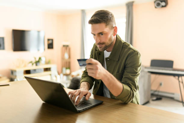 istock Nice man making order on his laptop at home 1394397687
