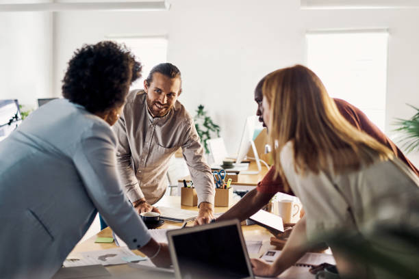 istock Group of businesspeople having a meeting standing around a table at work 1394398857