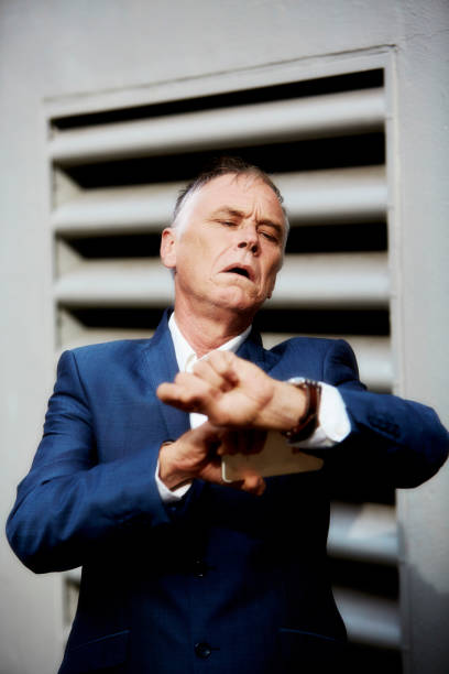 istock Middle age man checks the time on this wrist watch 1394401971