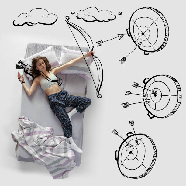 istock Creative image. Young woman lying on bed, sleeping, dreaming about shooting a bow on target. Top view 1394404152