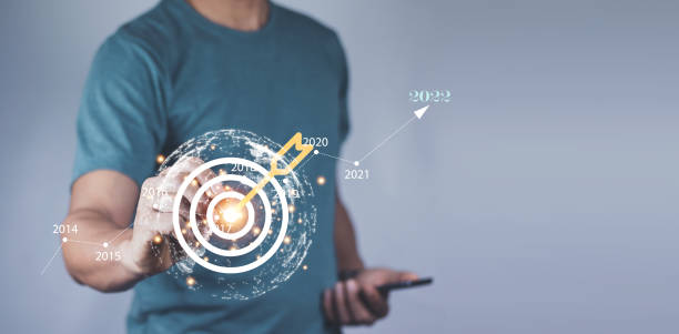 istock Man holding red arrow dart to virtual target dart board. Setup objectives and target for business investment concept, Digital marketing, Business goal and technology concept. 1394404688
